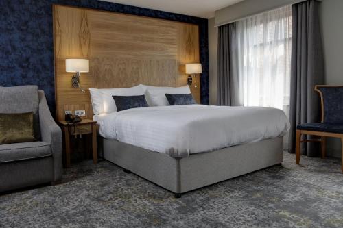 a bedroom with a large bed and a chair at Garner Hotel Nottingham City Centre by IHG in Nottingham