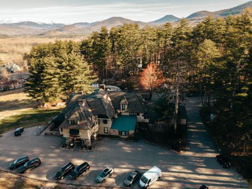 an aerial view of a house with cars parked in a parking lot at Stonehurst Manor Breakfast & Dinner Included in North Conway
