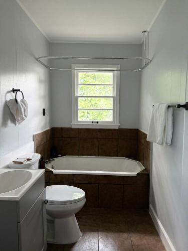 a bathroom with a tub and a toilet and a sink at Stylish Stay on Elizabeth-near to Cafes and Music in Lafayette