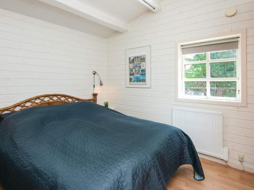 a bedroom with a bed with a blue blanket at 4 star holiday home in Hejls in Hejls