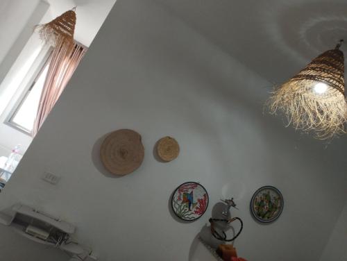 a white wall with four plates and a chandelier at Appartement 2 à Carthage byrsa in Douar ech Chott
