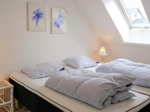two beds in a white room with a window at 5 star holiday home in Løkken in Løkken