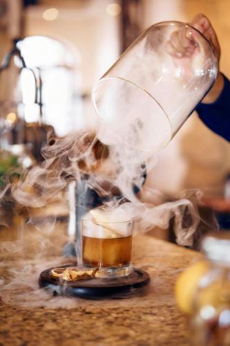 a person pouring a drink into a glass on a counter at Hacienda del Mar Los Cabos, an Autograph Collection All-Inclusive Resort in Cabo San Lucas