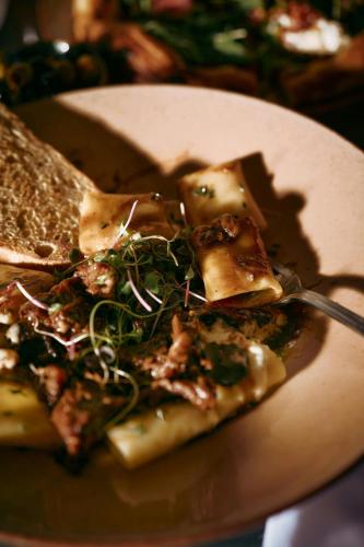 a slice of pizza on a plate with a fork at Hacienda del Mar Los Cabos, an Autograph Collection All-Inclusive Resort in Cabo San Lucas