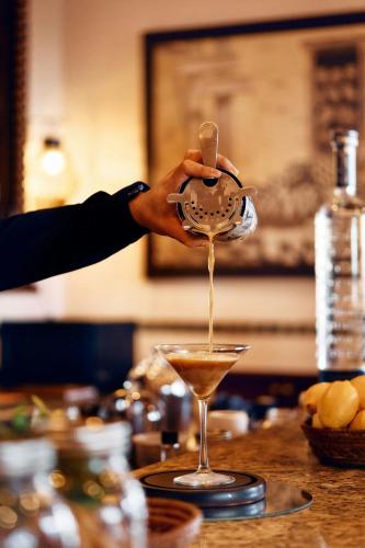 a person pouring a drink into a martini glass at Hacienda del Mar Los Cabos, an Autograph Collection All-Inclusive Resort in Cabo San Lucas