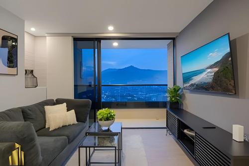 Una sala de estar con un sofá y una ventana grande. en Class 48 Apt. 2604 - Vida moderna-vistas a la ciudad/AC, en Sabaneta