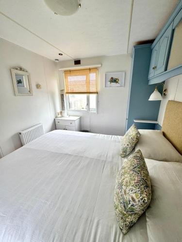a bedroom with a large white bed and a window at Fraunie's Beach House Anderby Creek - Dog friendly in Anderby