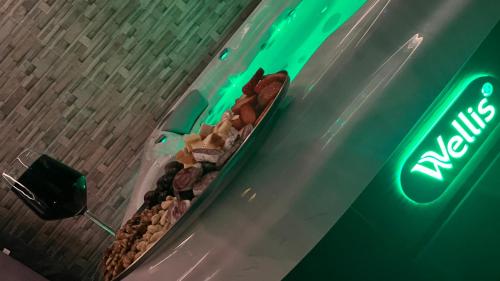 a display of donuts on a table with a neon sign at Greyhouse Apartments in Harkány