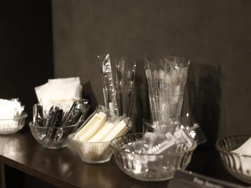 a counter with several glass bowls and utensils on it at MONOMINAHOTELstn1 in Ōmuta