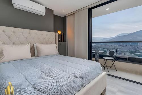 a bedroom with a bed and a large window at Class 48 Apt. 2202 - Apt luminoso/Balcón/AC in Sabaneta