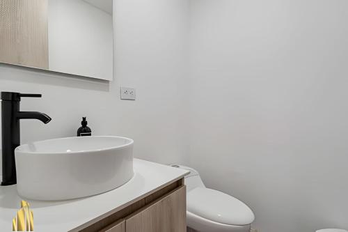 a white bathroom with a sink and a toilet at Class 48 Apt. 2202 - Apt luminoso/Balcón/AC in Sabaneta