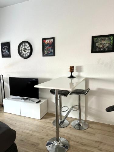 a living room with a white table and a tv at NEU MotoLoft Schwarzwaldhochstraße Zentrum Goldstadt Pforzheim Schlössle in Pforzheim