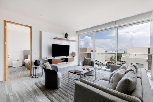 a living room with a couch and a tv at Luxurious 4BR condo by the beach - Rooftop pool in Cancún