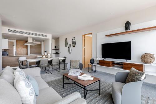 a living room with a couch and a tv at Luxurious 4BR condo by the beach - Rooftop pool in Cancún