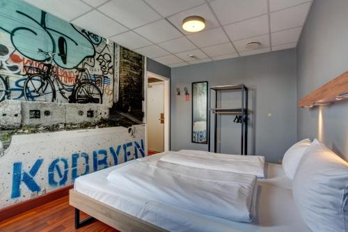 a bedroom with two beds and a graffiti wall at Urban House Copenhagen by MEININGER in Copenhagen