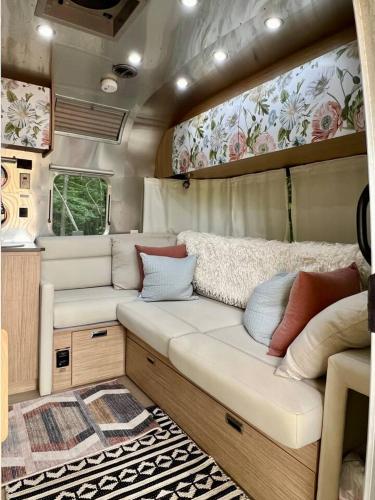 an interior of a rv with a couch and a rug at Moonbeam Airstream in Oakland