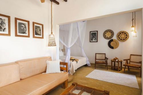a living room with a couch and a bed at Poa Poa Bungalows in Kiwengwa