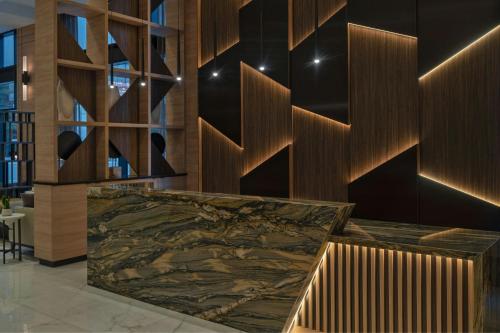 a lobby with a marble counter and wooden walls at AC Hotel by Marriott Wichita Downtown in Wichita