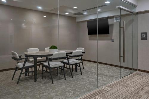 a conference room with a table and chairs and a screen at AC Hotel by Marriott Wichita Downtown in Wichita
