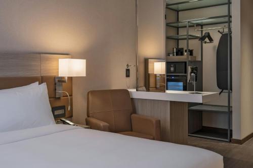 a hotel room with a bed and a kitchen at AC Hotel by Marriott Wichita Downtown in Wichita