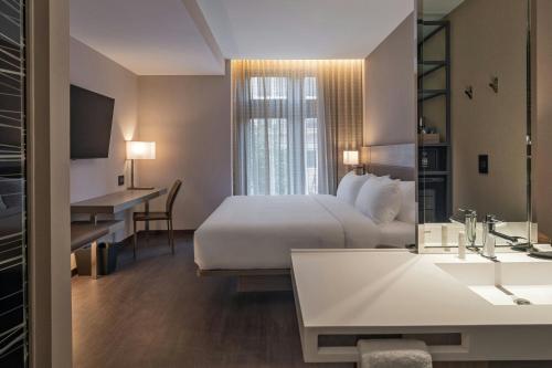 a hotel room with a bed and a sink at AC Hotel by Marriott Wichita Downtown in Wichita