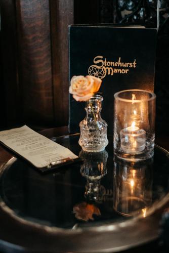a glass vase with a flower and candles on a table at Stonehurst Manor Breakfast & Dinner Included in North Conway