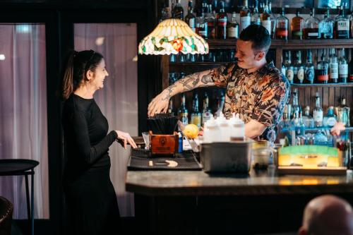 a man and a woman standing behind a bar at Stonehurst Manor Breakfast & Dinner Included in North Conway