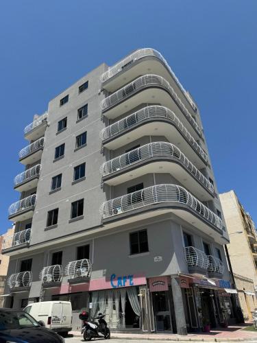 a tall gray building with balconies and a motorcycle parked in front at New Luxury 2 Single Bed Studio Apartment- BV3 in St Paul's Bay