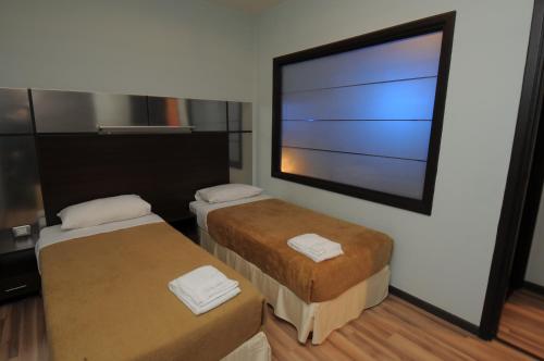 a room with two beds and a large window at Suite Hotel Chrome - Beirut in Beirut