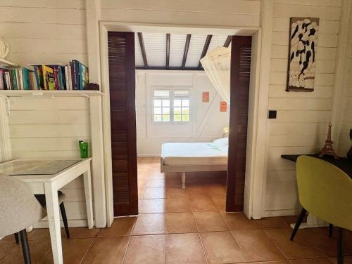 a room with a bedroom with a bed and a table at Villa Ti Sable - Escale entre mer et nature in Saint-Pierre