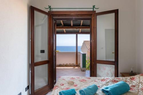 una camera da letto con una porta aperta sulla vista dell'oceano di Casa Fenicottero - Pet Friendly - Funtana Meiga a Funtana Meiga