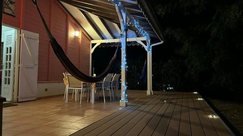 a porch with a hammock on a house at night at Villa Ti Sable - Escale entre mer et nature in Saint-Pierre