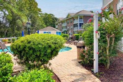 a courtyard with a pool and some bushes and a building at Gardens at Cypress Bay 19-104 in Little River