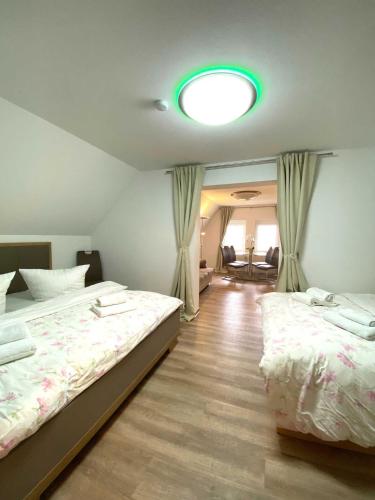 a bedroom with two beds and a green light at Süderhaus Hiddensee App 11 in Neuendorf