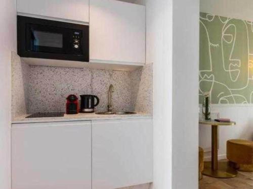 une cuisine avec un micro-ondes et un plan de travail dans l'établissement Chic studio for 2 people - Pigalle Sacré-C ur, à Paris