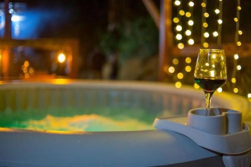a glass of wine sitting next to a swimming pool at Sierra Linda Glamping in Aibonito