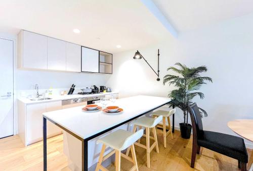 una cocina con una gran isla blanca en una habitación en Brilliant Quay Blvd Apt Close to Wyndham Harbour, en Werribee South