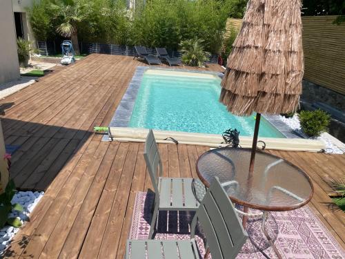 - une terrasse avec une table et des chaises à côté de la piscine dans l'établissement l'Esquirou, à Malemort-du-Comtat