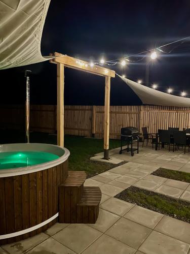 a patio with a hot tub and a tent at night at Chalet in the Slovak Paradise in Hnilčík