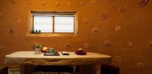 Una mesa en una habitación con ventana y velas. en Punggi Red Clay Pension, en P'unggi