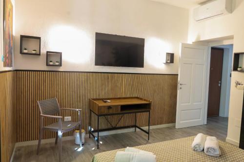 a room with a desk and a television on a wall at Health House in Sassari