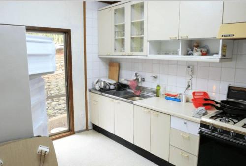 a kitchen with white cabinets and a sink at Goseong Choi Pil Khan Gotek 