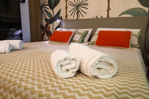 a bed with two laptops and towels on it at Health House in Sassari