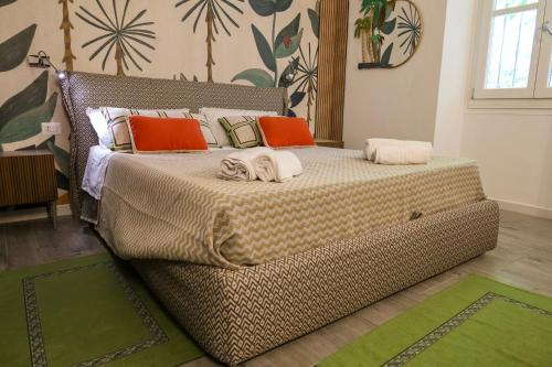 a bedroom with a large bed with orange and green pillows at Health House in Sassari