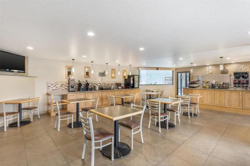 a restaurant with tables and chairs and a kitchen at Best Western Plus Great Northern Inn in Havre