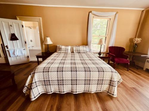 a bedroom with a bed with a checkered blanket at Stonehurst Manor Breakfast & Dinner Included in North Conway