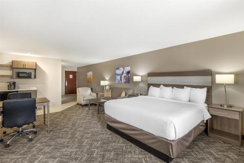 a hotel room with a bed and a desk at Best Western Plus Great Northern Inn in Havre
