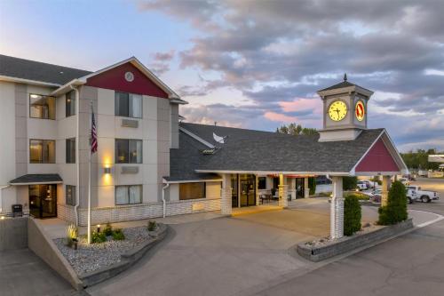 a hotel with a clock tower in front of a building at Best Western Plus Great Northern Inn in Havre
