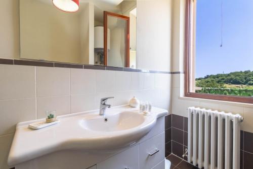 a bathroom with a sink and a mirror and a radiator at Villa with Sea View Parking in Lapedona