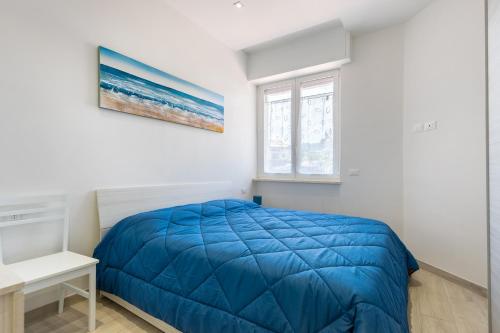 a bedroom with a blue bed and a window at Hostdomus - Blumar in Diano Castello